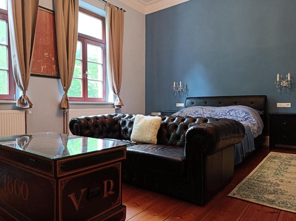 ein Wohnzimmer mit einem Sofa und einem Bett in der Unterkunft Herrenhaus Harmshagen in Testorf-Steinfort