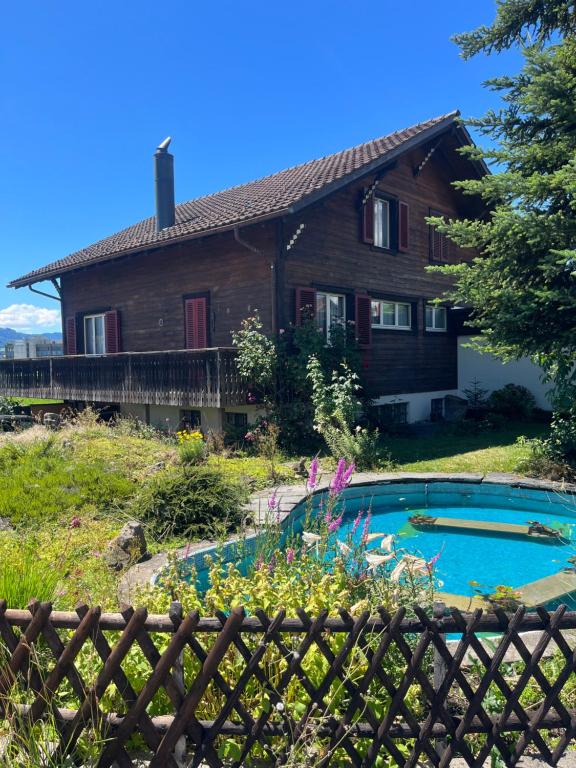 a house with a pool in front of it at Gemütliches Chalet an bester Lage in Jona
