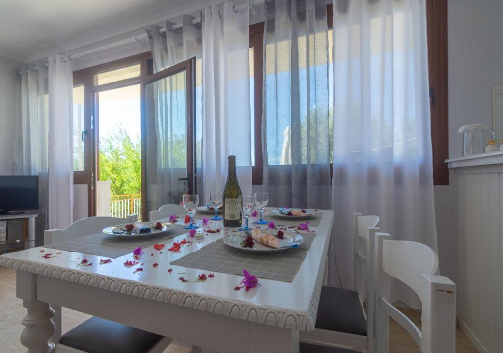 a white dining room table with a bottle of wine at Anthoula house in Vlachopoulátika