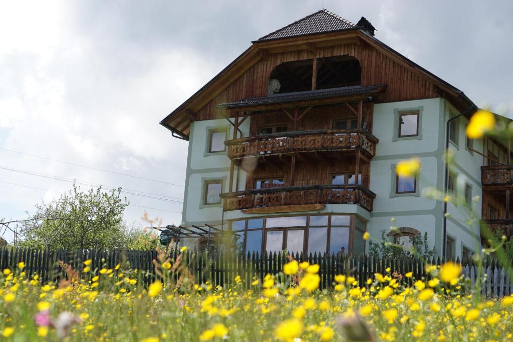 una casa con balcón y un campo de flores en Hainererhof en Mauterndorf