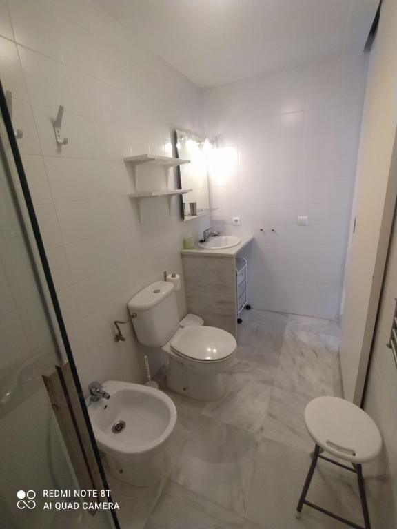 biała łazienka z toaletą i umywalką w obiekcie Ático-Duplex Las Palmeras w mieście Conil de la Frontera