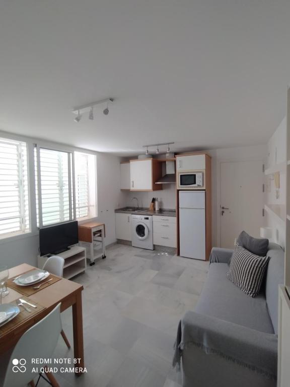 salon z kanapą i kuchnią w obiekcie Ático-Duplex Las Palmeras w mieście Conil de la Frontera