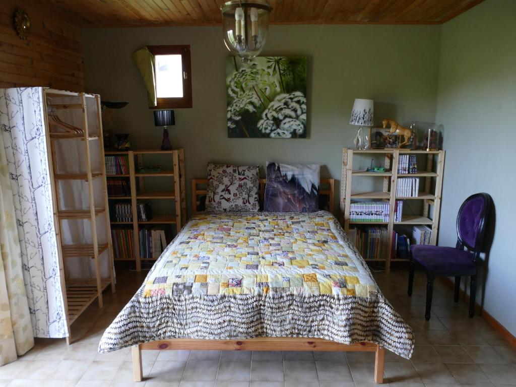a bedroom with a bed with a quilt on it at Chambre indépendante deux personnes au bord de la Blanche in Selonnet