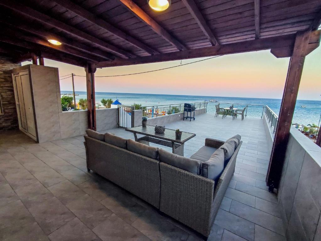 a patio with couches and a view of the ocean at Nostalgia Apartment in Archangelos