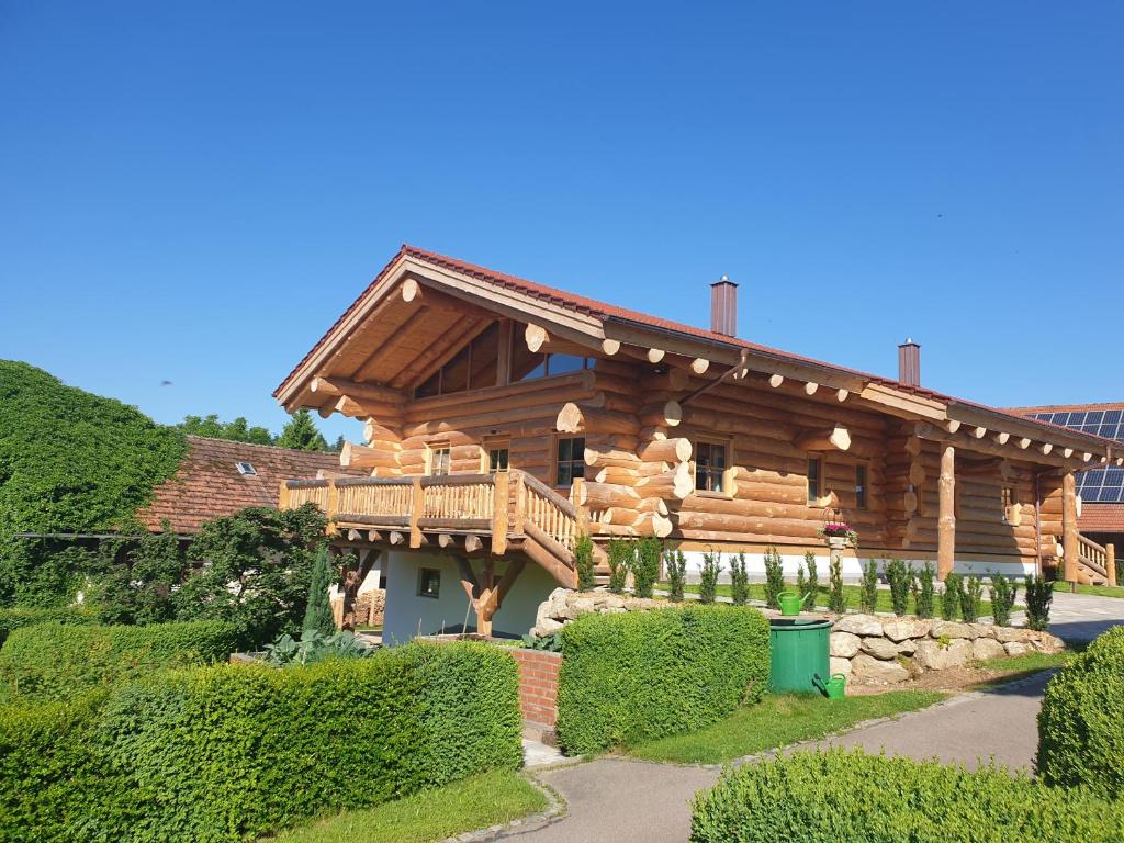 a log cabin with a porch and a deck at Hüttenzauber Laumer in Wörth an der Donau