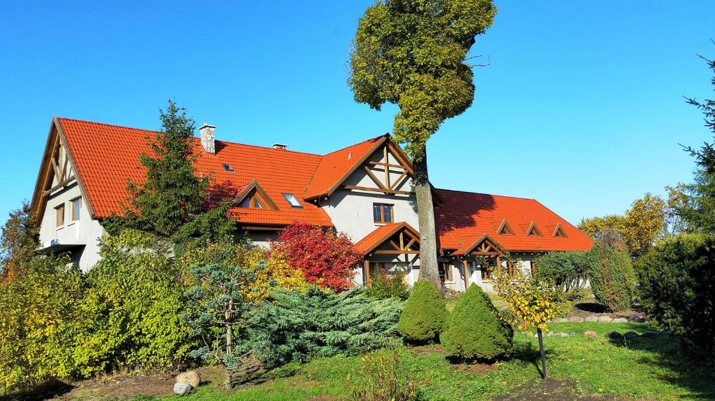 une grande maison avec un toit orange dans l'établissement Dom Uzdrowisko, à Tolkmicko