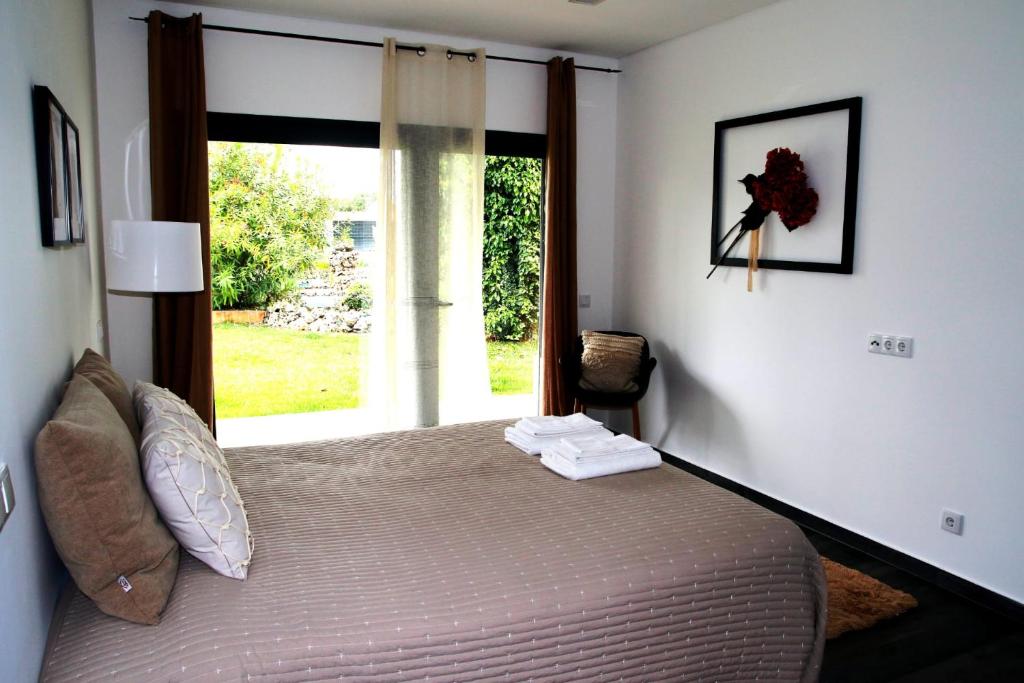 a bedroom with a large bed with a window at Garden Apartment Dona Amélia in Abrantes