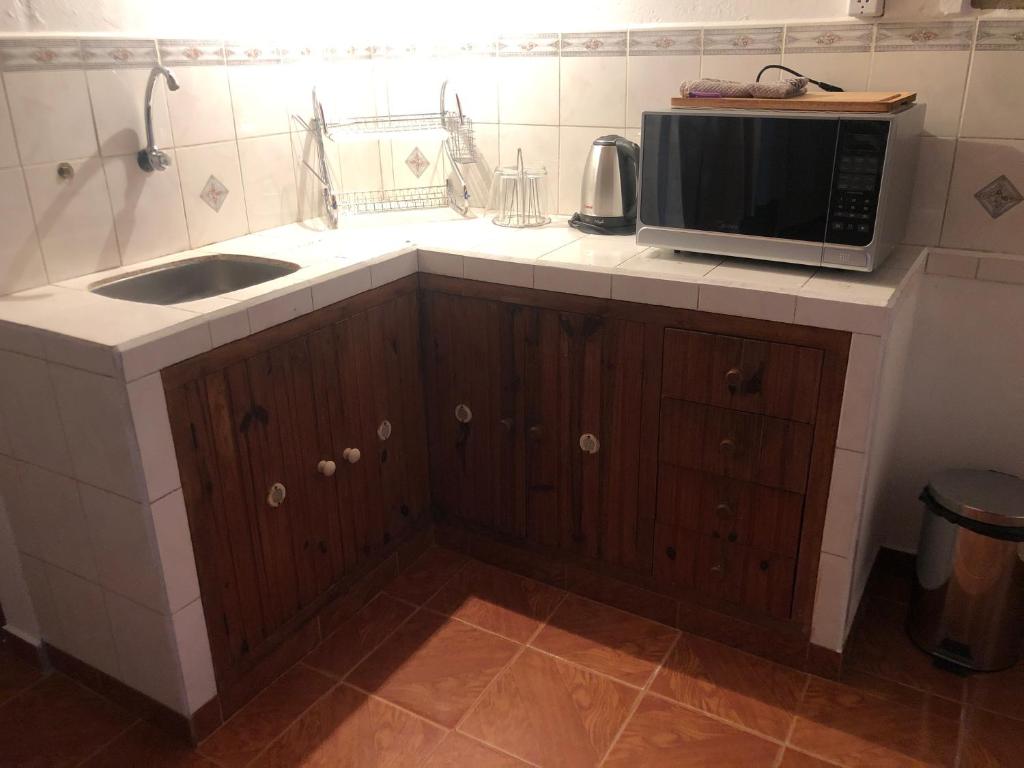 una cocina con fregadero y microondas en una encimera en LA POSADA en Aiguá