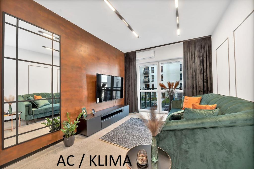 uma sala de estar com um sofá e uma televisão em Luxury Copper Apartment em Lódź