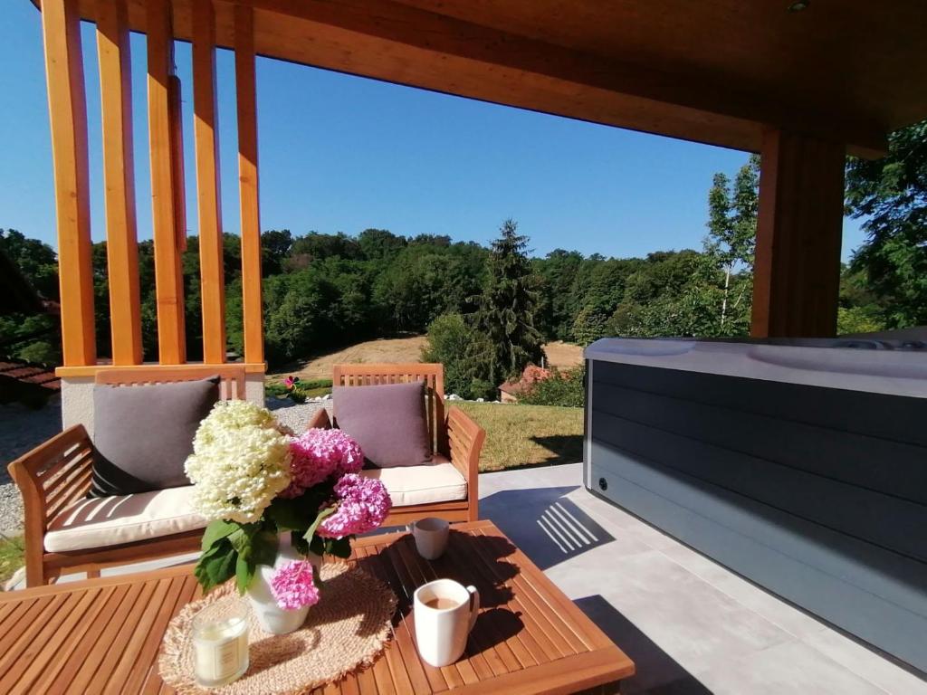 a patio with a television and a table with flowers at Villa Magnolia in Sveti Martin na Muri
