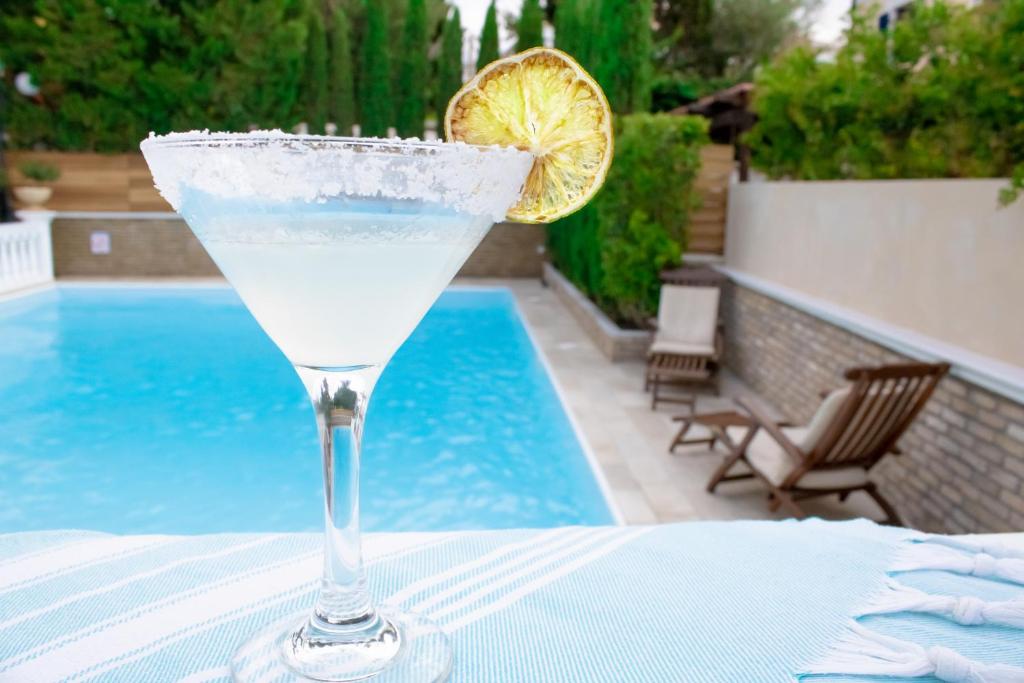 a drink sitting on a table with a lemon slice at Armata Boutique Hotel in Spetses