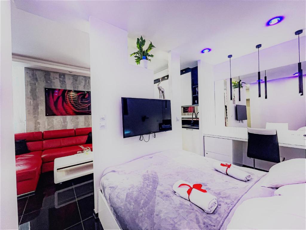 a bedroom with a bed and a red couch at Apartament Cieplicka in Jelenia Góra