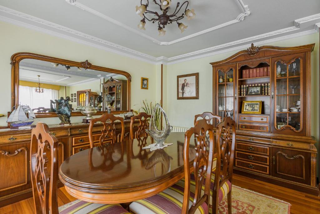jadalnia ze stołem i lustrem w obiekcie Villa Cecilia - Casa marinera con piscina y jardín w mieście Colindres