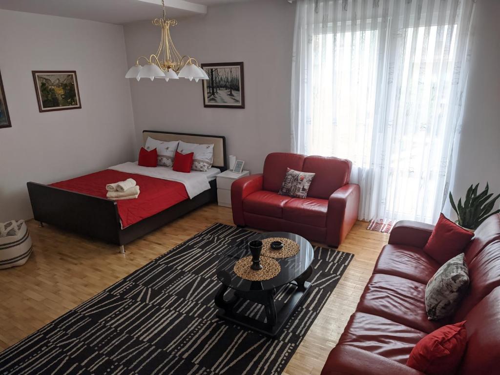 een woonkamer met een bed en een bank bij Apartman Sabah in Novi Pazar