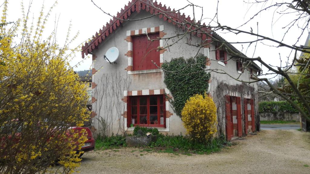 une maison avec des portes rouges et du lierre dans l'établissement Les Bambous, à Sauveterre-la-Lémance