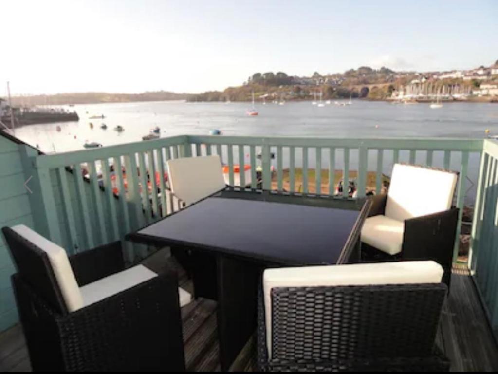 a table and chairs on a balcony with a view of the water at Tamar View in Plymouth