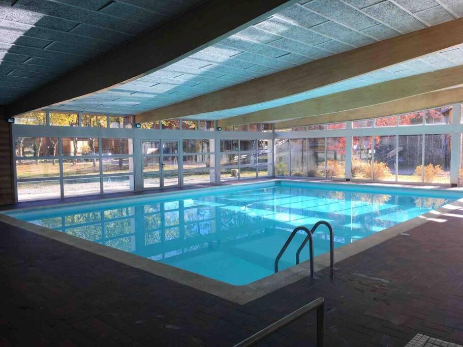 duży basen w budynku w obiekcie Appart. lumineux pour 4pers. avec piscine chauffée w mieście Saint-Laurent-du-Jura