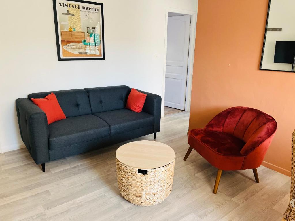 een woonkamer met een bank en een stoel bij Appartement Cosy en coeur de vieille ville in Boulogne-sur-Mer
