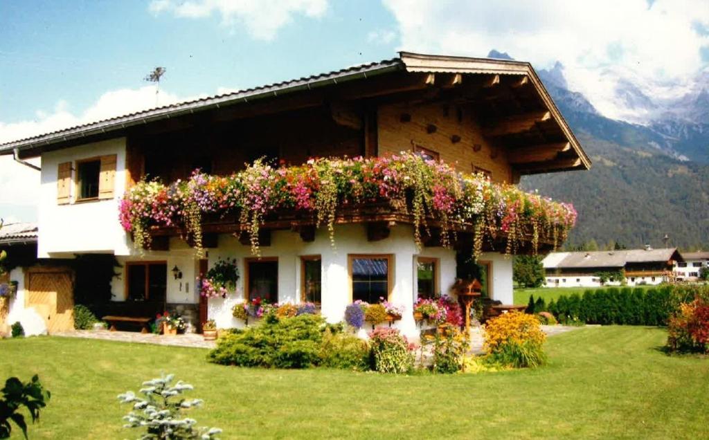 ein Haus mit Blumen auf der Seite in der Unterkunft Merryshof in Sankt Ulrich am Pillersee