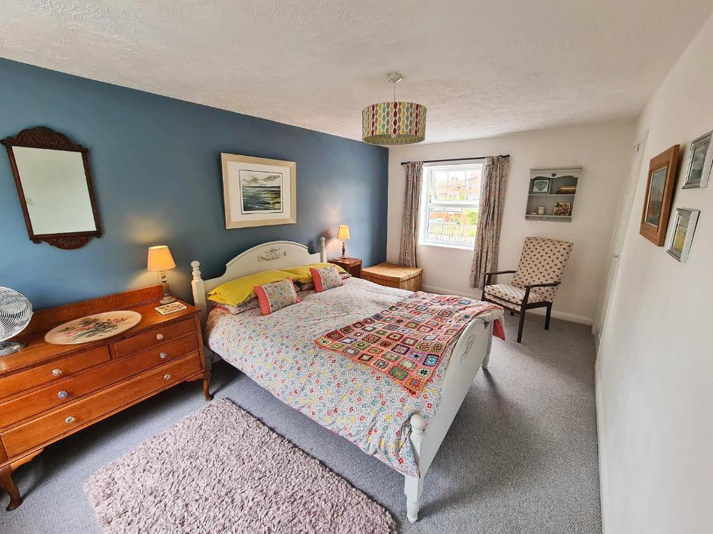 a bedroom with a bed and a table and a chair at Chapel Bricks-dog friendly cottage near the coast in Withernwick