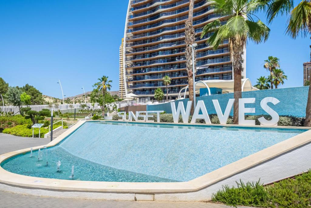 een zwembad voor een hoog gebouw bij Sunset Waves 5-143 in Benidorm