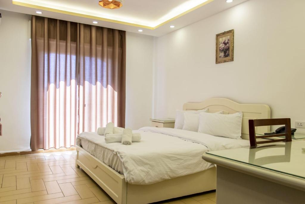 um quarto com uma cama, uma secretária e uma janela em Irbid Plaza Hotel em Irbid
