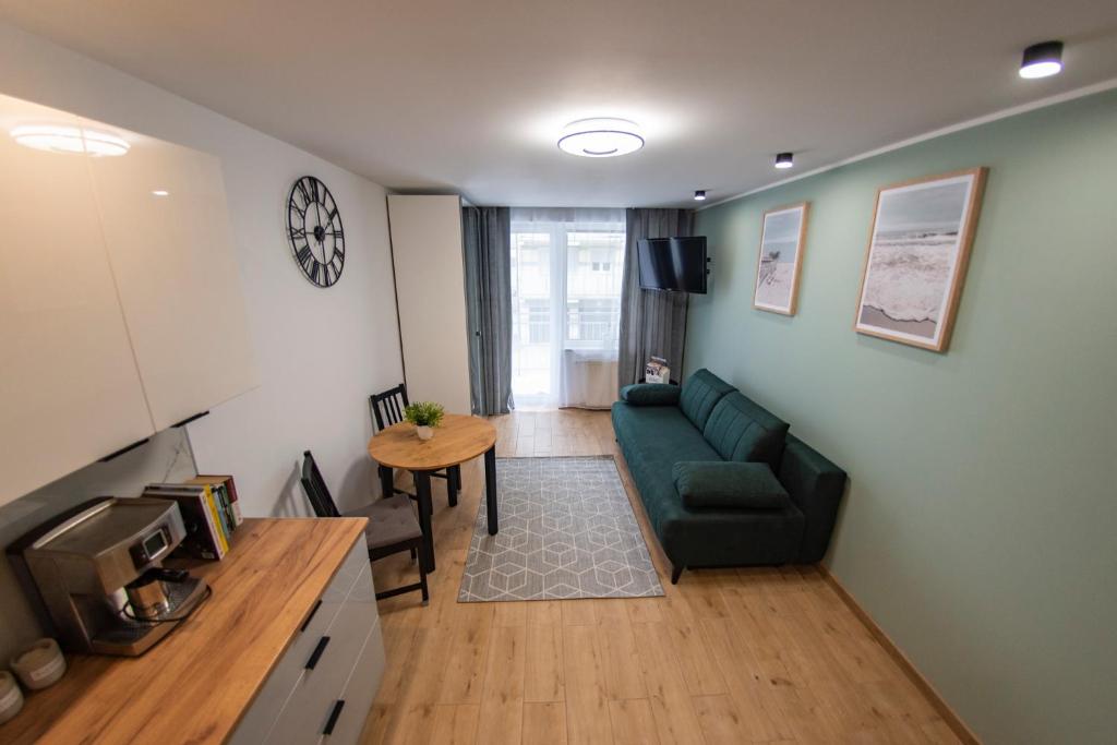 a living room with a green couch and a table at Apartamenty Tercet, Apartament Sonata in Ustka