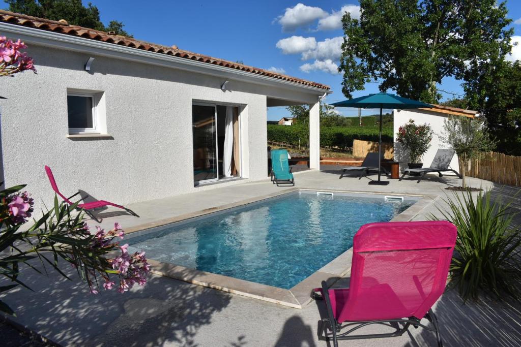 a swimming pool with chairs and a house at Gite des Clapas Flora, villa avec piscine privée in Balazuc