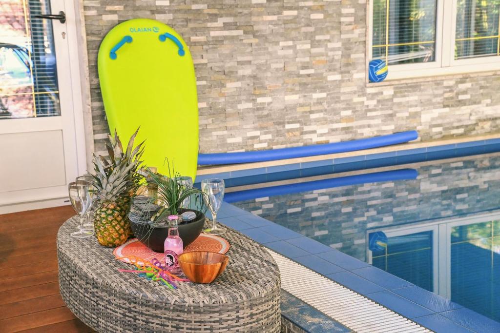 a surfboard sitting on a table next to a pool at Apartmani Kraljevica in Kraljevica