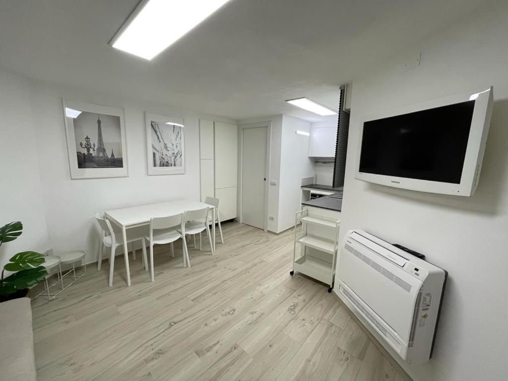 a living room with a table and a tv on a wall at Lido Appartamento Parcheggio Privato 400 mt dal mare in Lido di Camaiore