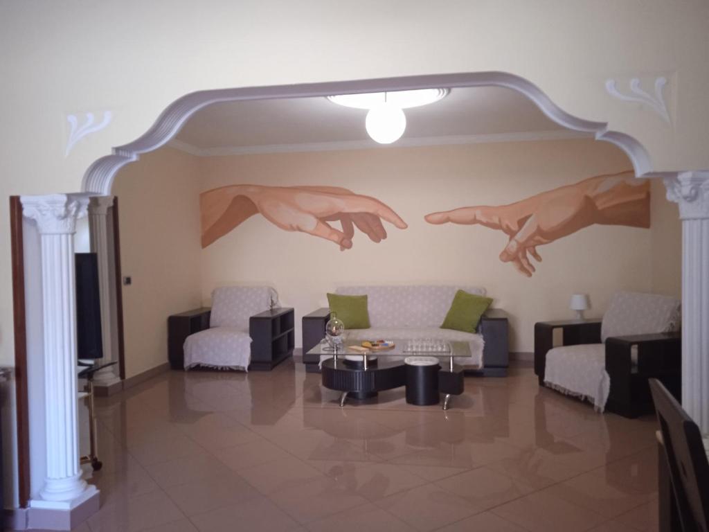 a living room with a painting of hands on the wall at B&B Paraiso del Sol in Maspalomas