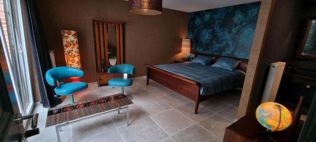 sypialnia z łóżkiem i 2 niebieskimi krzesłami w obiekcie Logies La Chèvre Folle w Ostendzie
