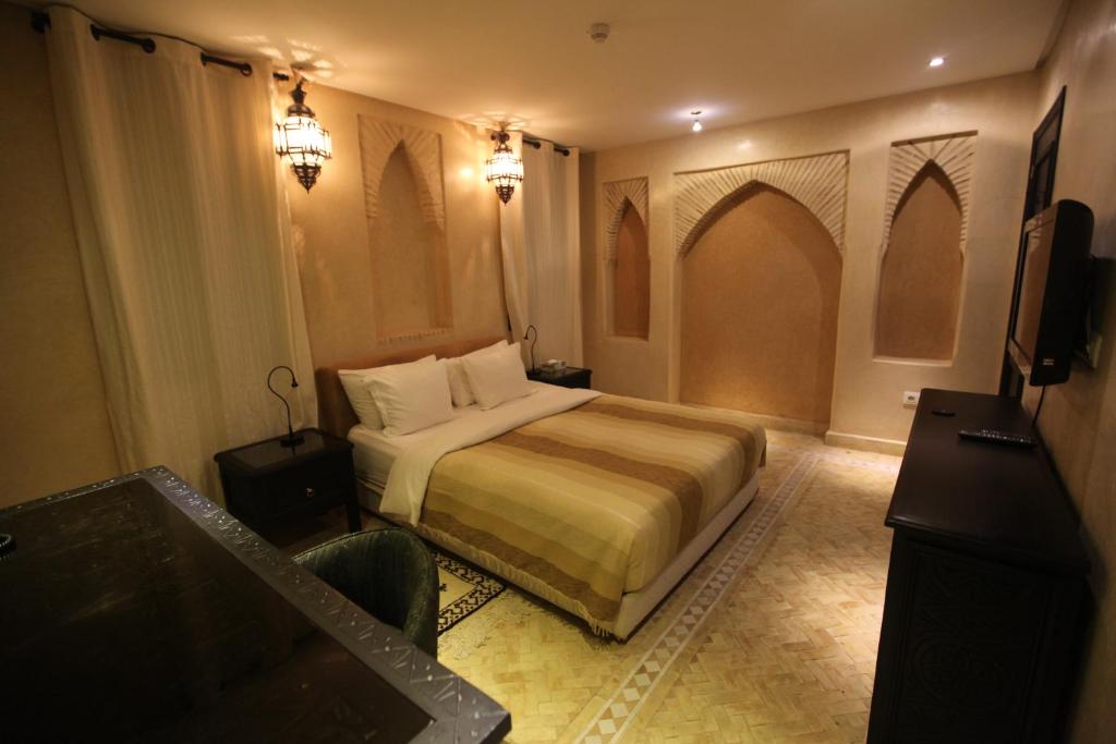 a hotel room with a bed and a television at Riad Dar Haven in Tamraght Ou Fella