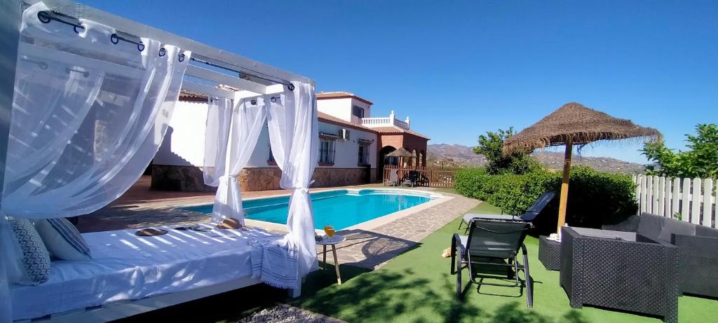 een patio met een bed en een zwembad bij Villa yasleni in Málaga