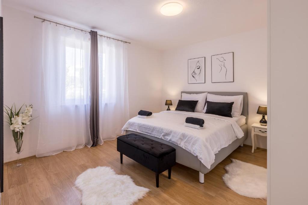 a white bedroom with a large bed and a window at New Apartments Nenna - Three Bedroom Near Split in Mravince