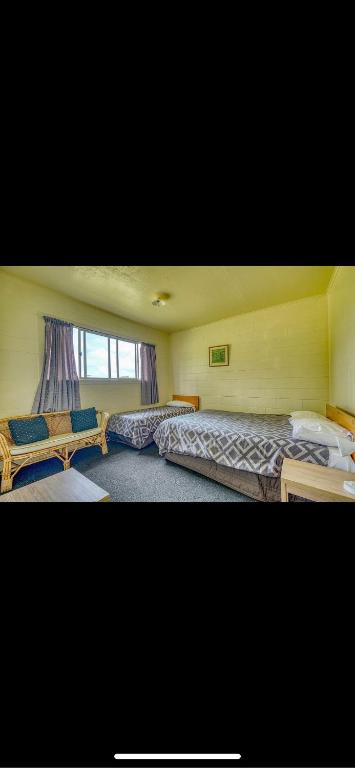 Tekao Lodge في Te Kao: غرفة نوم بسريرين ونافذة