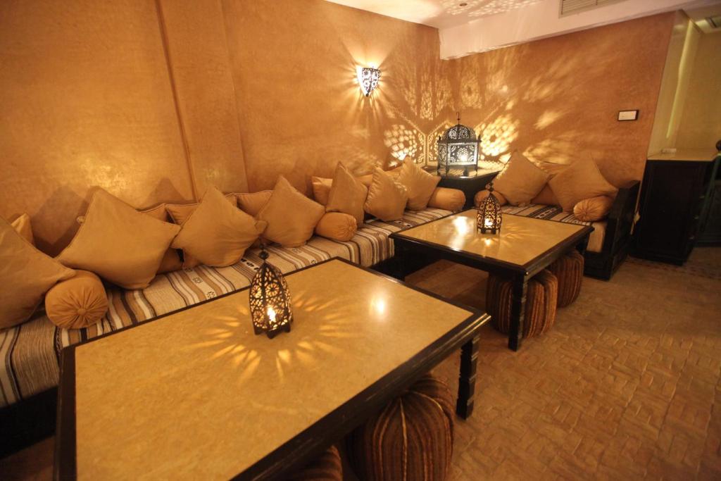 a living room with a couch and two tables at Riad Dar Haven in Tamraght Ou Fella