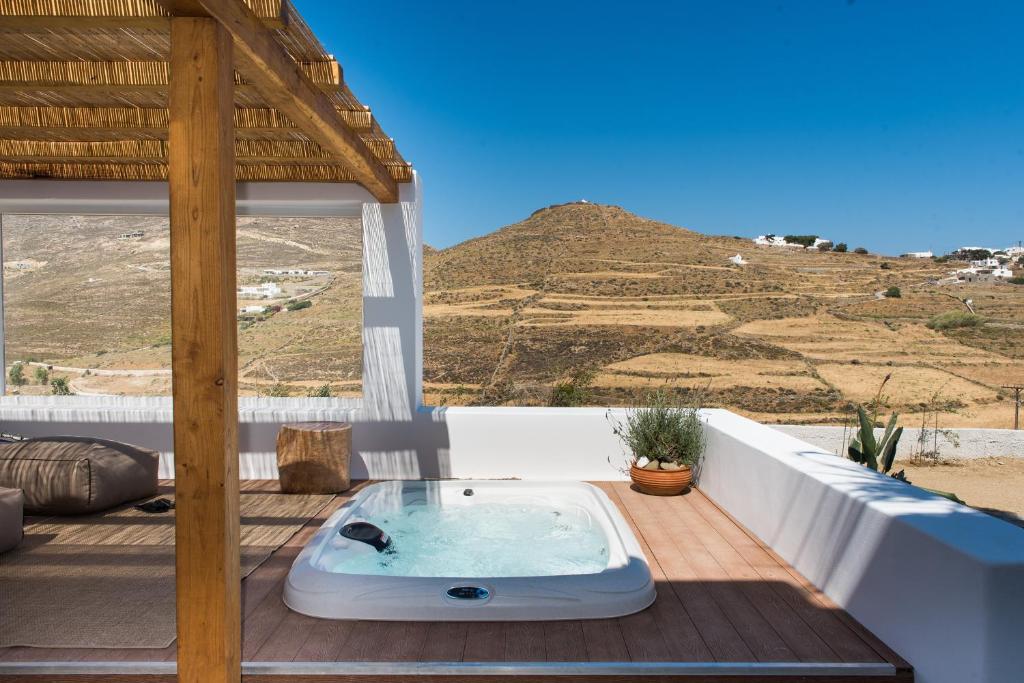 a hot tub on a deck with a view of a mountain at Levantes House Mykonos in Ano Mera