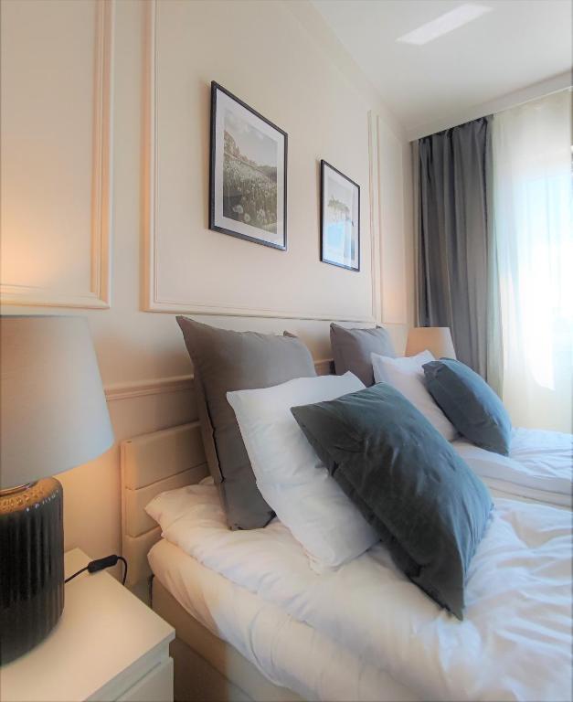 a bedroom with two beds with pillows and a window at Riverside - nad rzeką, centrum, Netflix i Max, parking, winda in Iława