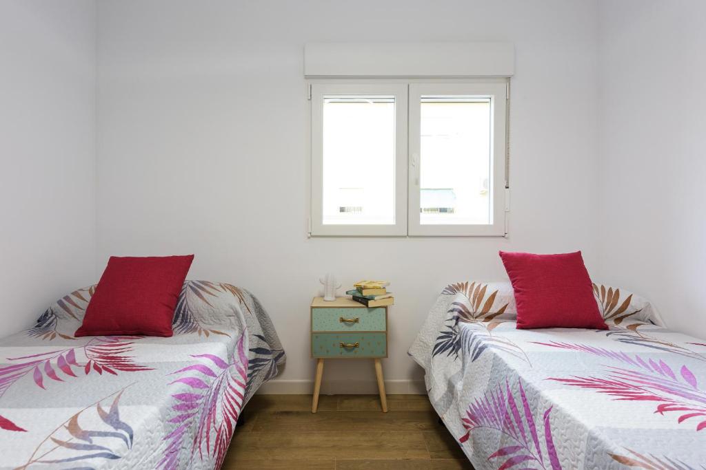 2 camas en una habitación con 2 ventanas en Apartamento Lagloria, en Granada