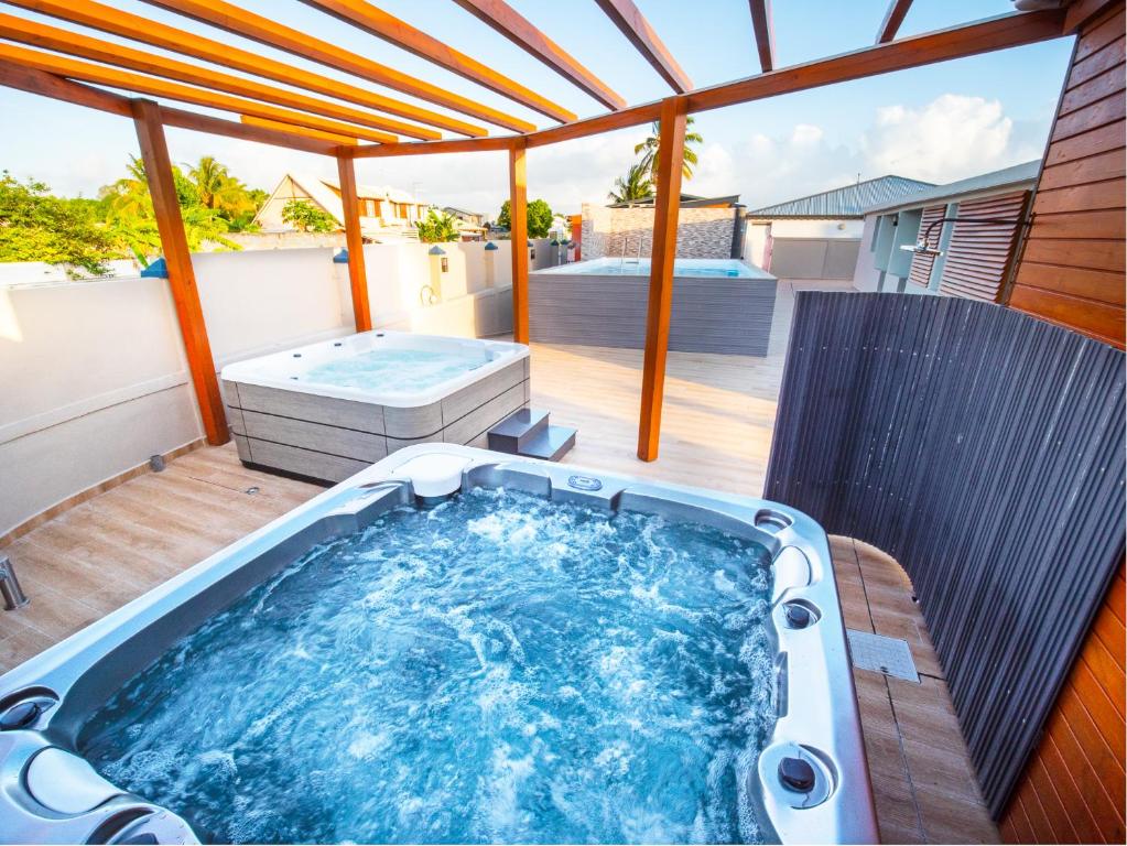 bañera de hidromasaje en la cubierta de una casa en Studio Jacuzzi et piscine au centre ville de Port-Louis, en Port-Louis