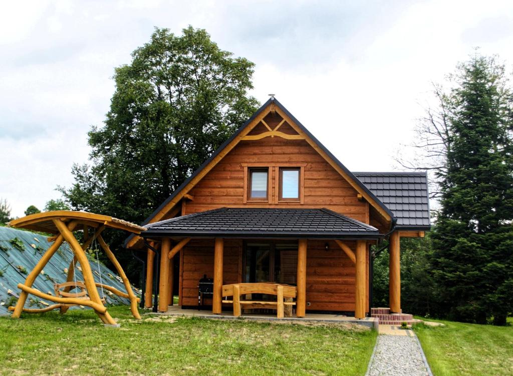 a log cabin with a slide and a playground at Bieszczadzkie Dworki Ropienka Dolna in Ustrzyki Dolne
