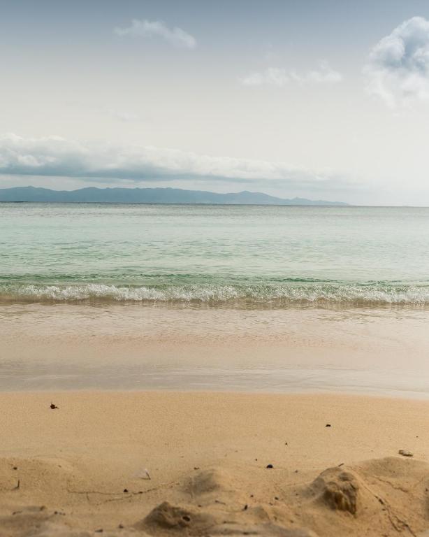 a sandy beach with the ocean in the background at T2 jacuzzis et piscine au centre ville de Port-Louis in Port-Louis