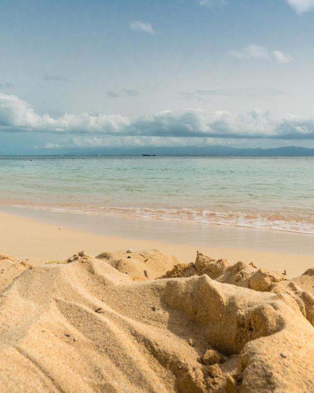 a sandy beach with the ocean in the background at T2 jacuzzis et piscine au centre ville de Port-Louis in Port-Louis
