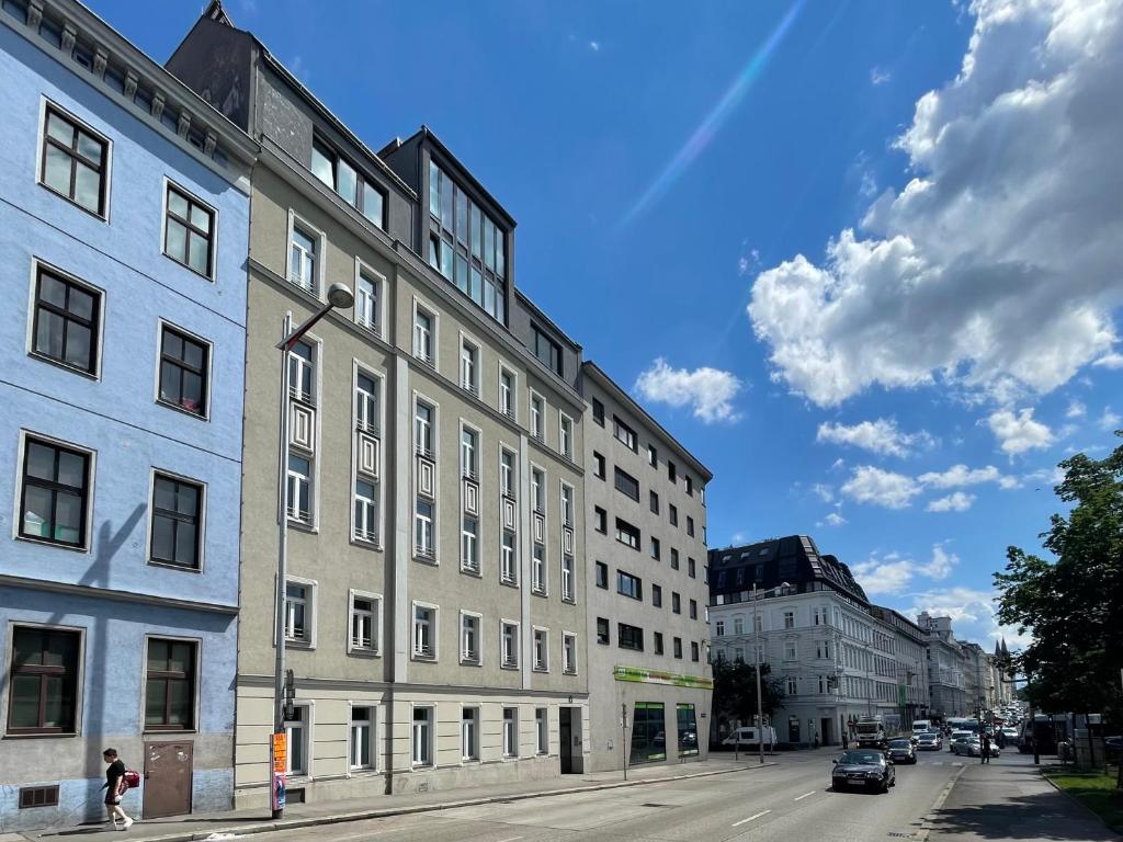 un grand bâtiment dans une rue de la ville avec des voitures dans l'établissement Flarent Vienna Apartments-WG, à Vienne