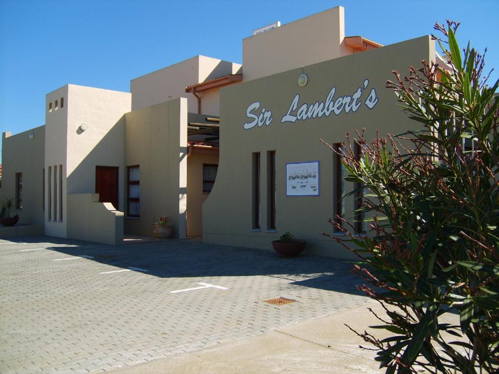 a building with a sign on the side of it at Sir Lambert's Guesthouse in Lambertʼs Bay