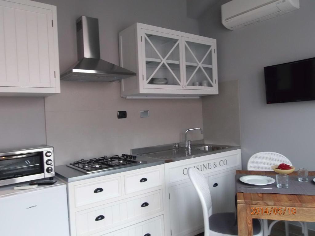 a kitchen with white cabinets and a sink and a stove at Casa Vacanze SanGiacomo in Santo Stefano al Mare