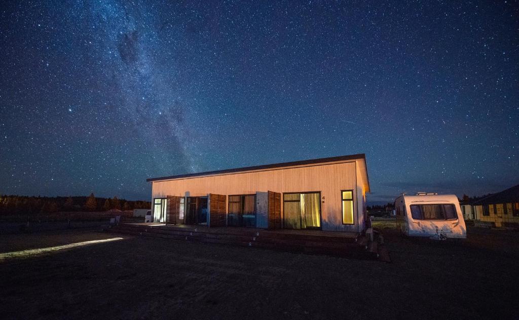 a small building in a parking lot at night at Alpine Studios in Lake Tekapo