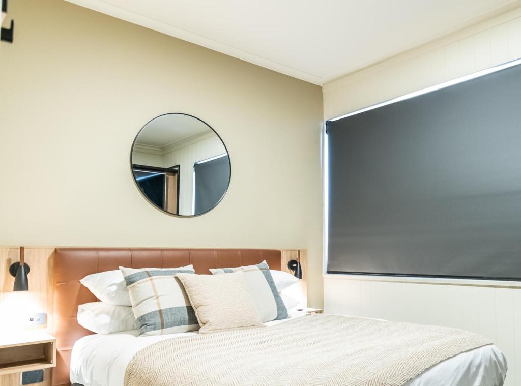 a bedroom with a large mirror above a bed at Eyre Hotel in Whyalla