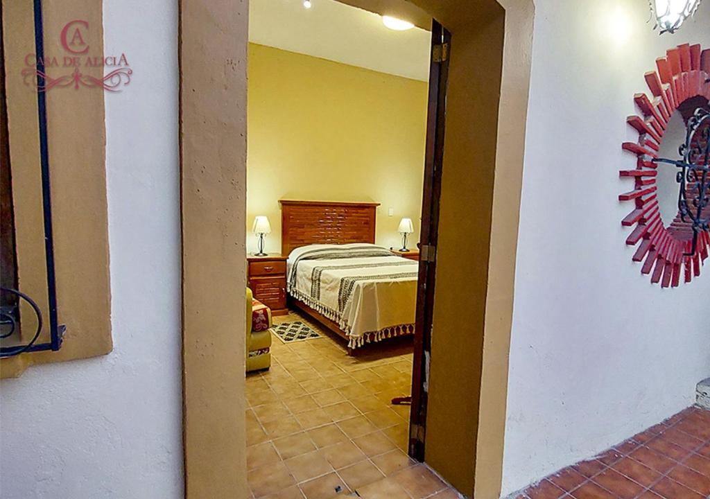 Casa de Alicia Departamento Yagul في مدينة أواكساكا: غرفة نوم مع سرير في غرفة مع مرآة